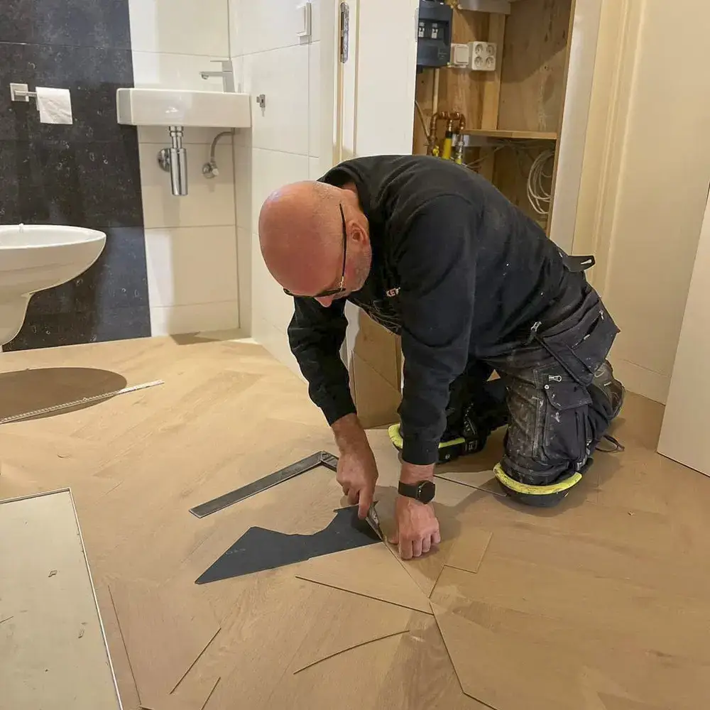 Monteur van Parkertreus snijd PVC delen op maat