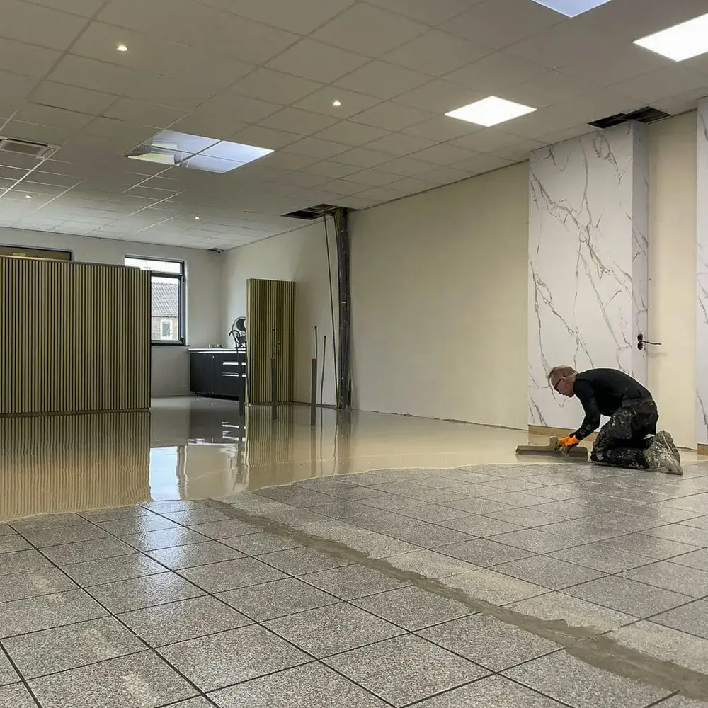 Ron Schoen van Parketreus egaliseert een tegelvloer