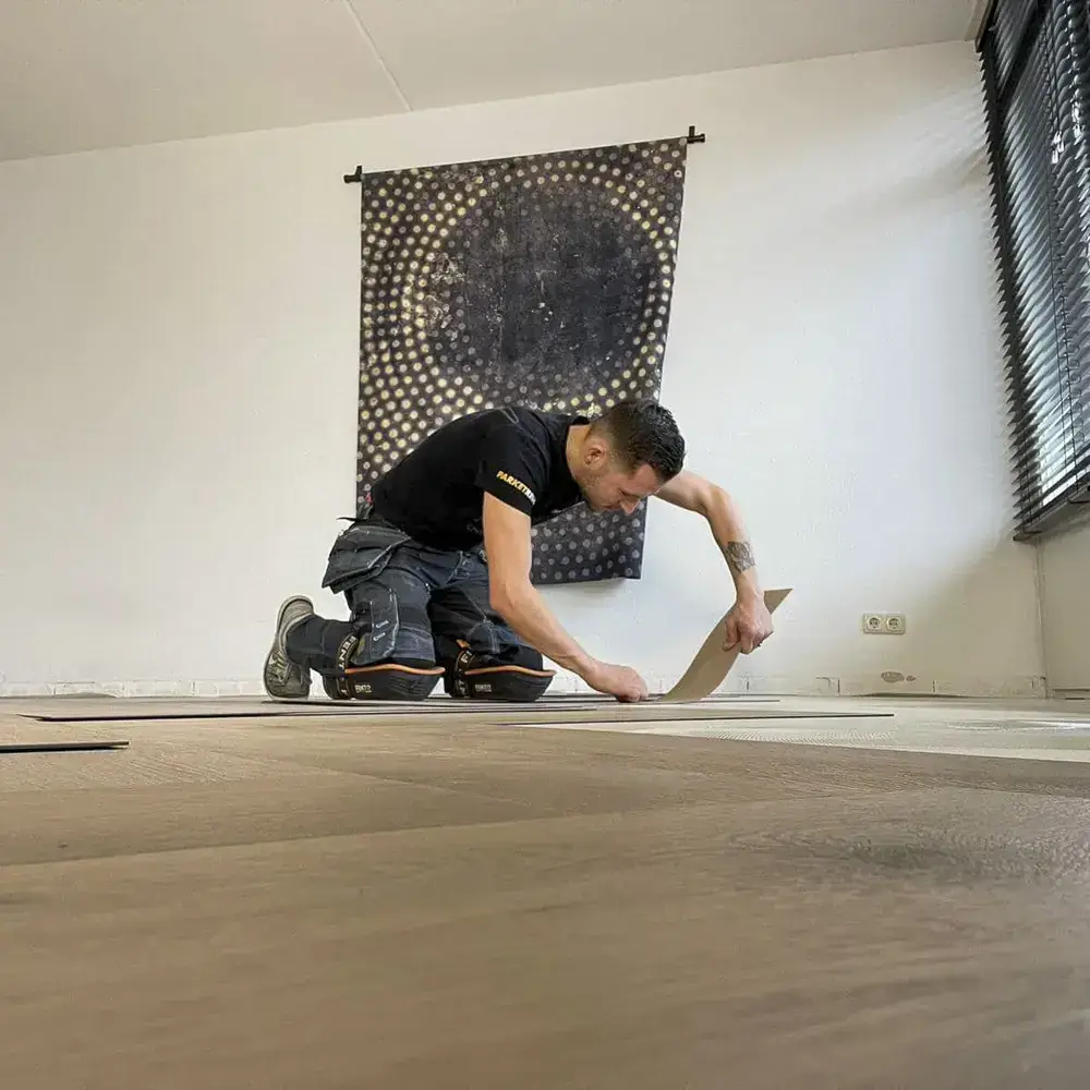 Monteur van Parketreus legt een PVC vloer