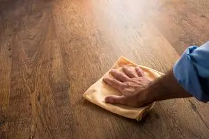 reinigen van houten vloeren met microvezeldoek. Man die vloer reinigt